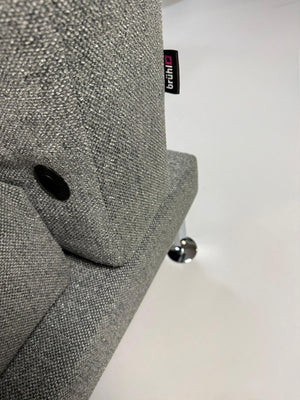 Gebrauchtes graues Brühl Moule Designer Stoff Sofa mit Hocker vor einer Wand, stilvoll und modern eingerichtet.