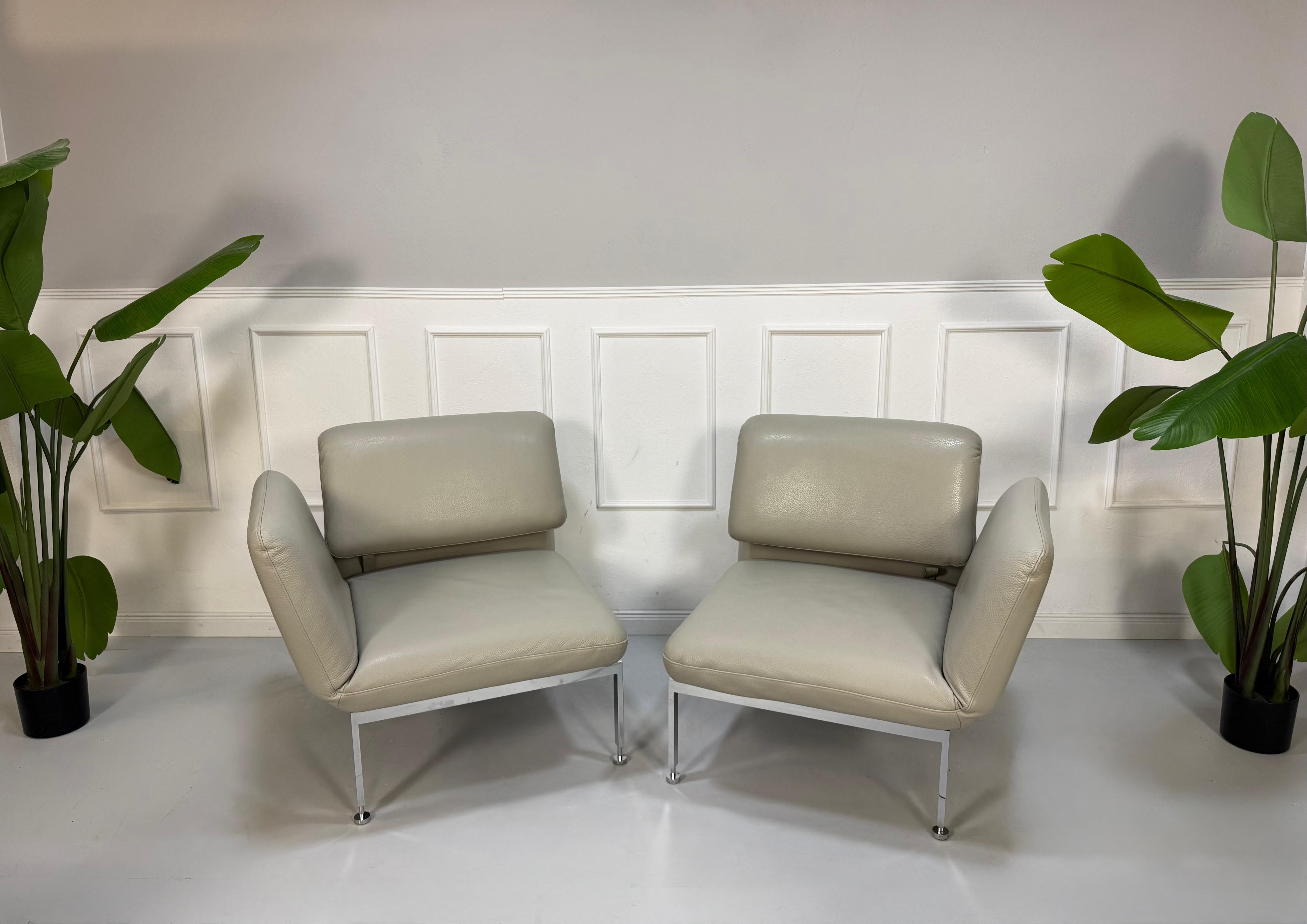 Gebrauchtes graues Brühl Roro Designer Leder Sofa vor einer Wand, stilvoll und modern eingerichtet.