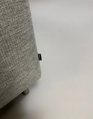 Refurbished graues Bolia Scandinavia Designer Stoff Sofa mit Hocker vor einer Wand, stilvoll und modern eingerichtet.