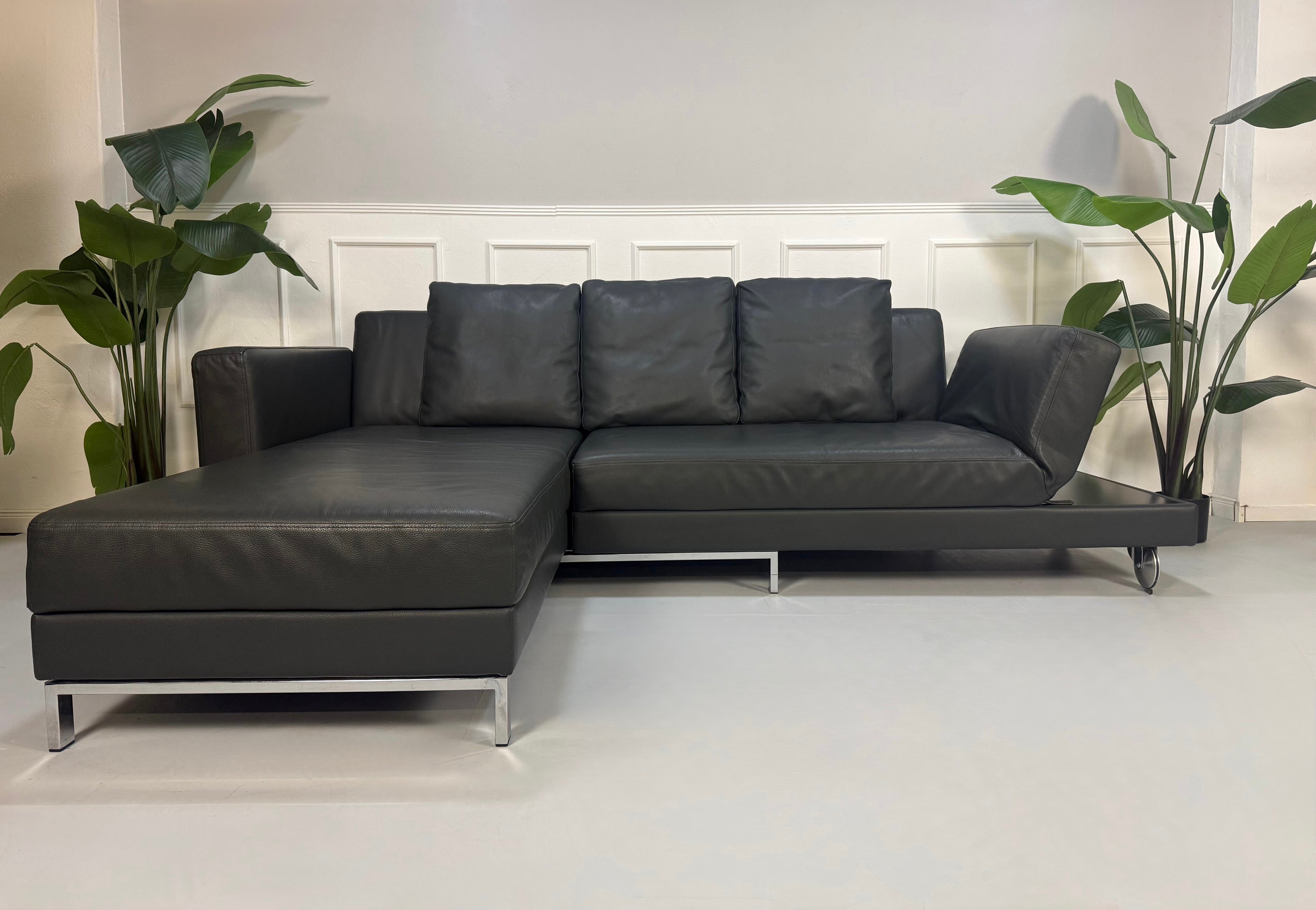 Gebrauchtes grau anthrazit Brühl Four Two Designer Leder Sofa vor einer Wand, stilvoll und modern eingerichtet.