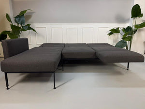 Gebrauchtes graues Brühl Roro Soft Designer Stoff Sofa vor einer Wand, stilvoll und modern eingerichtet.
