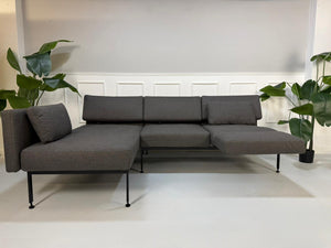 Gebrauchtes graues Brühl Roro Soft Designer Stoff Sofa vor einer Wand, stilvoll und modern eingerichtet.