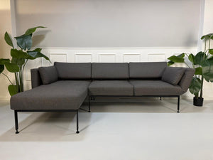 Gebrauchtes graues Brühl Roro Soft Designer Stoff Sofa vor einer Wand, stilvoll und modern eingerichtet.