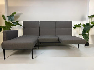 Gebrauchtes graues Brühl Roro Soft Designer Stoff Sofa vor einer Wand, stilvoll und modern eingerichtet.