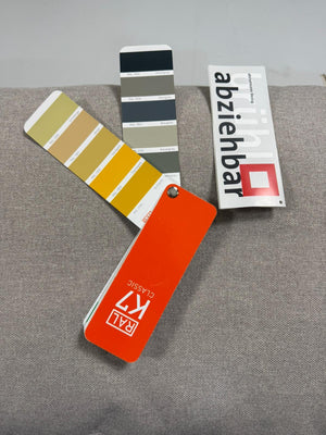 Gebrauchtes graues Brühl Moule Designer Stoff Sofa vor einer Wand, stilvoll und modern eingerichtet.