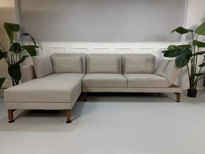 Gebrauchtes graues Brühl Moule Designer Stoff Sofa vor einer Wand, stilvoll und modern eingerichtet.