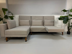 Gebrauchtes graues Brühl Moule Designer Stoff Sofa vor einer Wand, stilvoll und modern eingerichtet.
