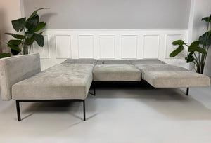 Gebrauchtes graues Brühl Roro Soft Designer Stoff Sofa vor einer Wand, stilvoll und modern eingerichtet.