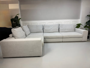 Erneuertes Flexform Groundpiece Designer Stoff Sofa vor einer Wand, stilvoll und modern eingerichtet.