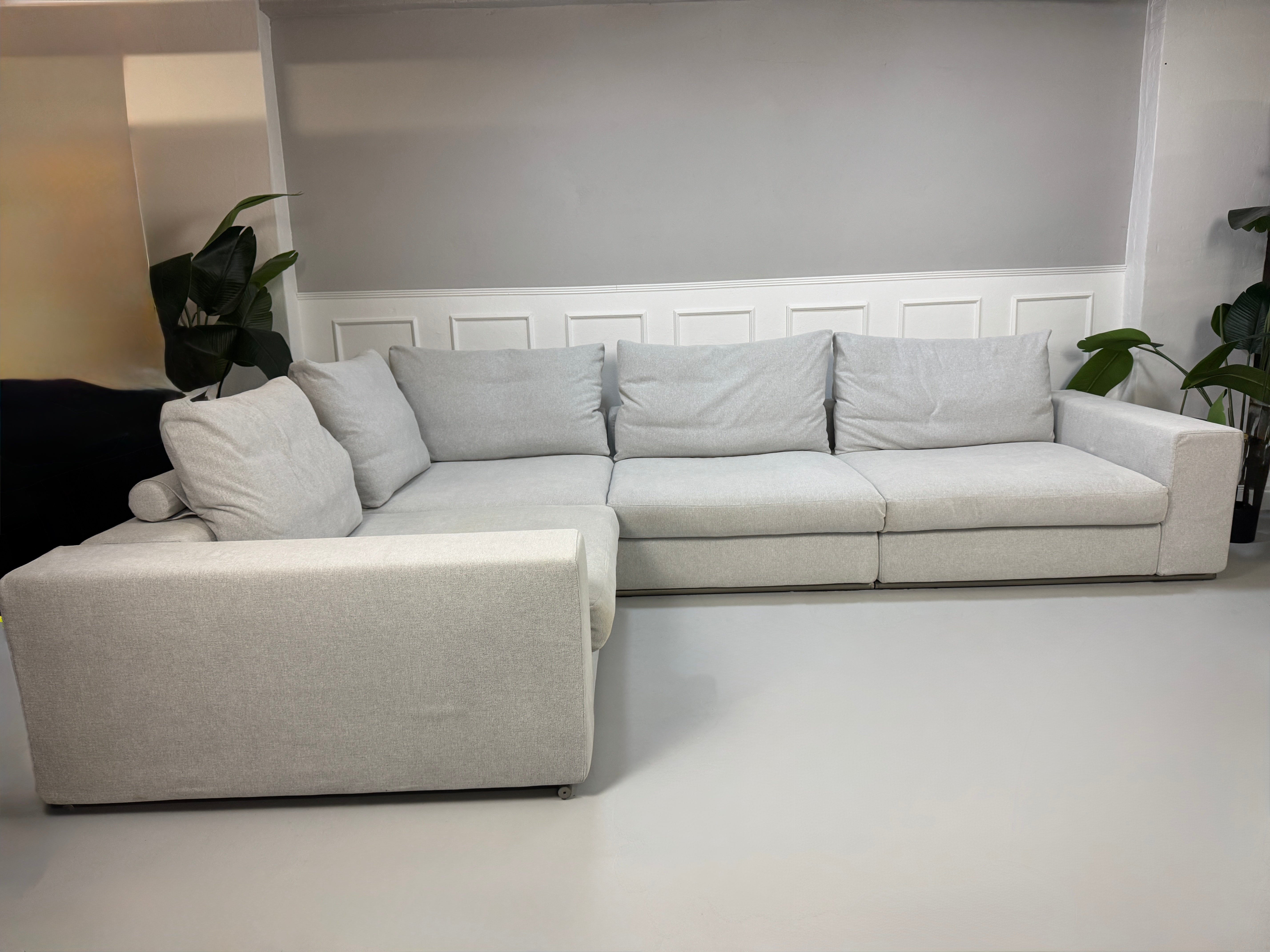 Erneuertes Flexform Groundpiece Designer Stoff Sofa vor einer Wand, stilvoll und modern eingerichtet.