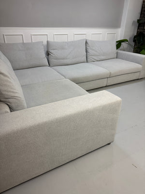 Erneuertes Flexform Groundpiece Designer Stoff Sofa vor einer Wand, stilvoll und modern eingerichtet.