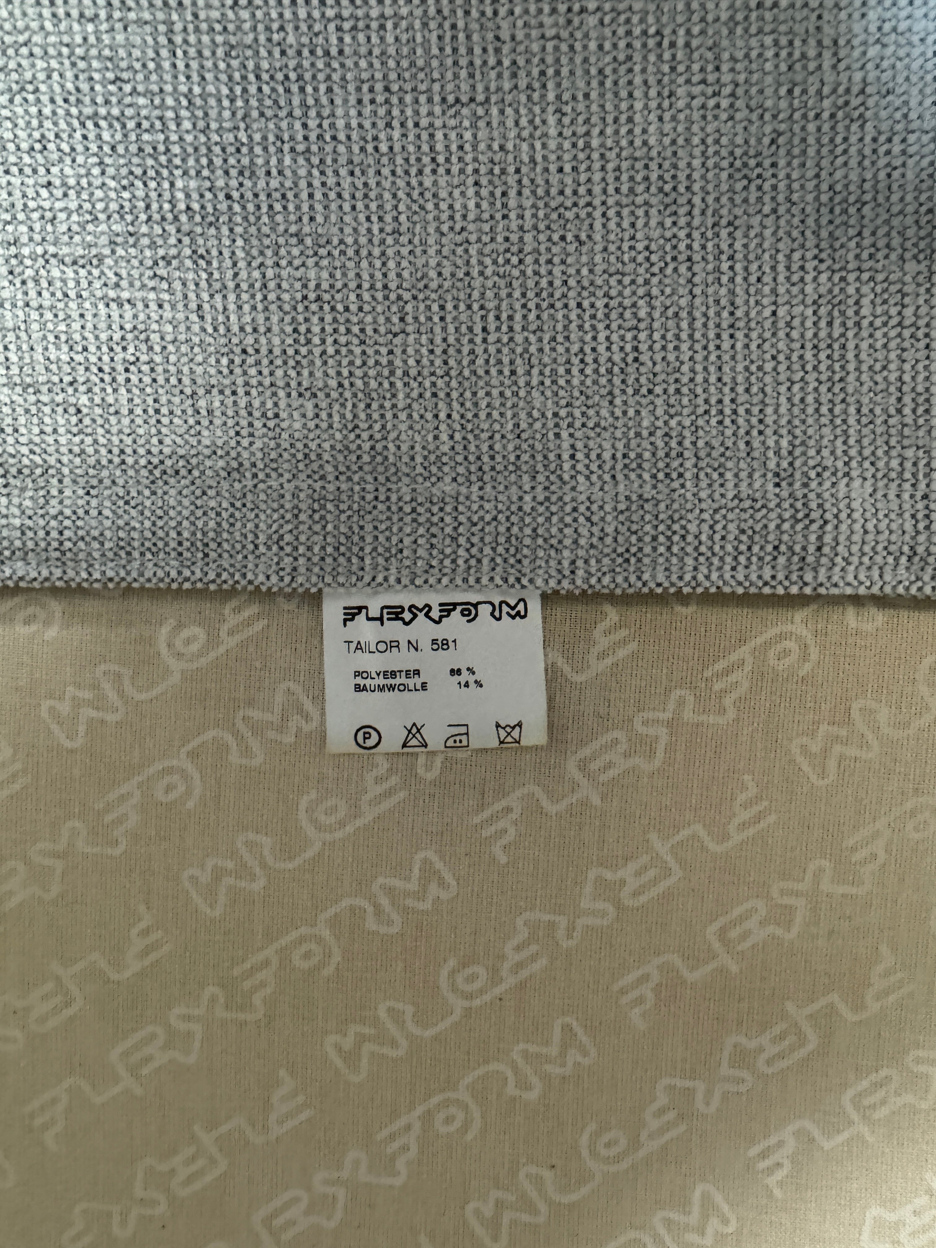 Erneuertes Flexform Groundpiece Designer Stoff Sofa vor einer Wand, stilvoll und modern eingerichtet.