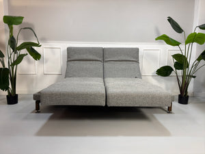 Gebrauchtes Brühl Moule Designer Stoff Sofa in der Farbe Grau vor einer Wand, stilvoll und modern eingerichtet.