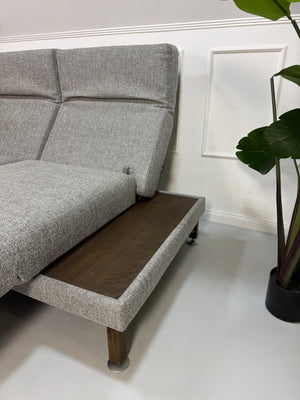 Gebrauchtes Brühl Moule Designer Stoff Sofa in der Farbe Grau vor einer Wand, stilvoll und modern eingerichtet.