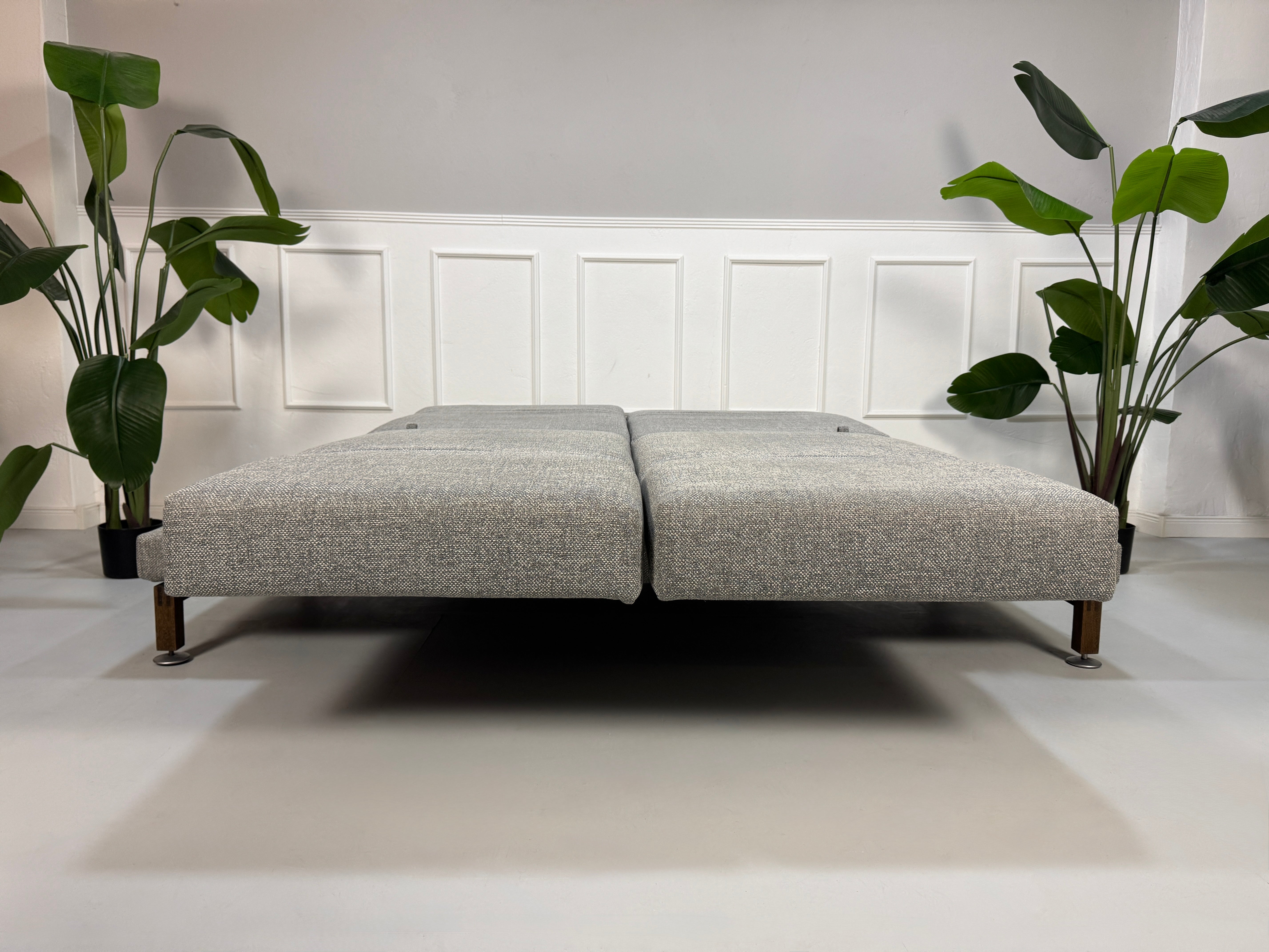 Gebrauchtes Brühl Moule Designer Stoff Sofa in der Farbe Grau vor einer Wand, stilvoll und modern eingerichtet.