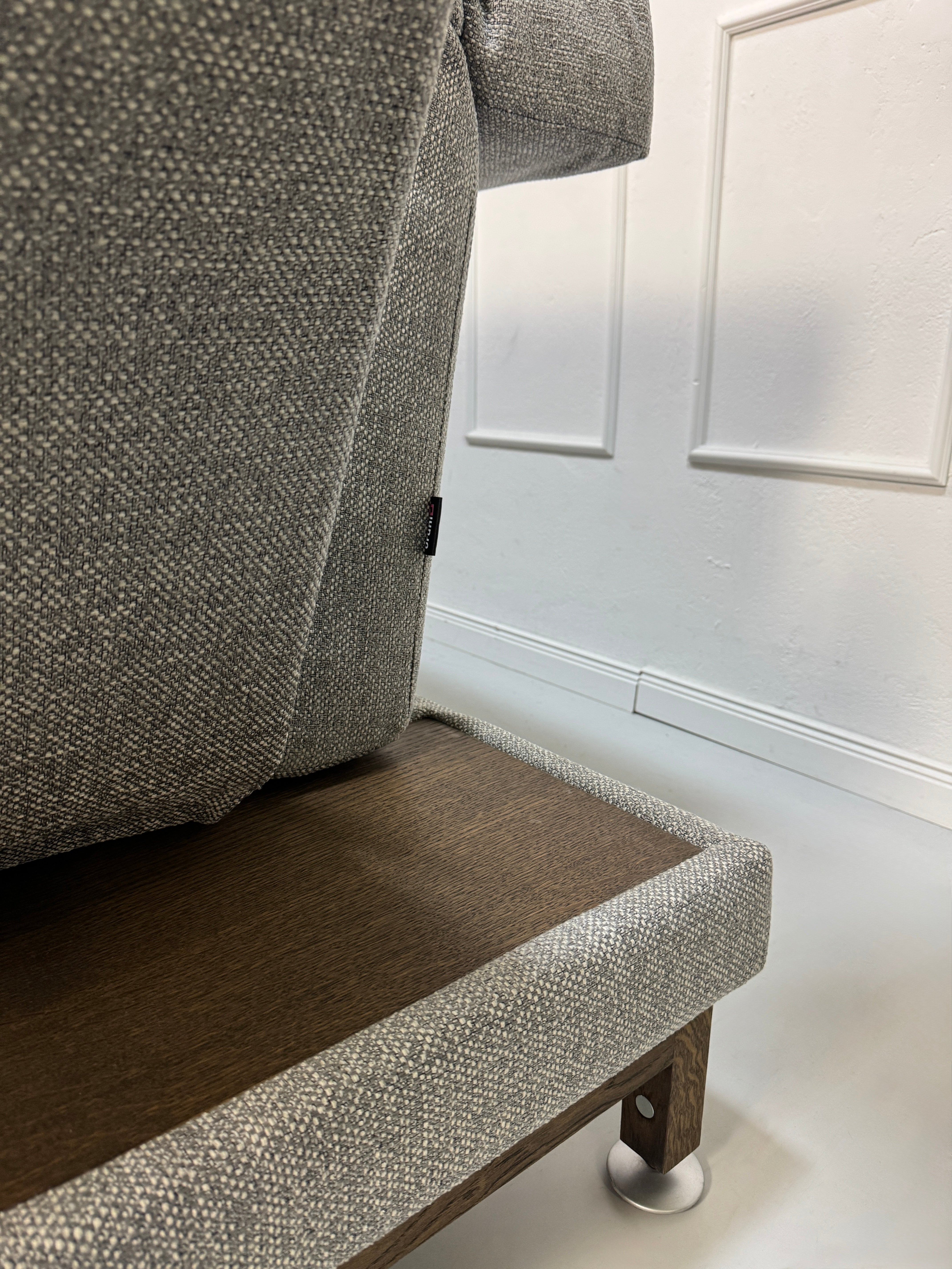 Gebrauchtes Brühl Moule Designer Stoff Sofa in der Farbe Grau vor einer Wand, stilvoll und modern eingerichtet.