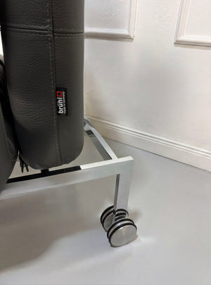 Gebrauchtes graues Brühl Roro Designer Leder Sofa mit Tisch vor einer Wand, stilvoll und modern eingerichtet.