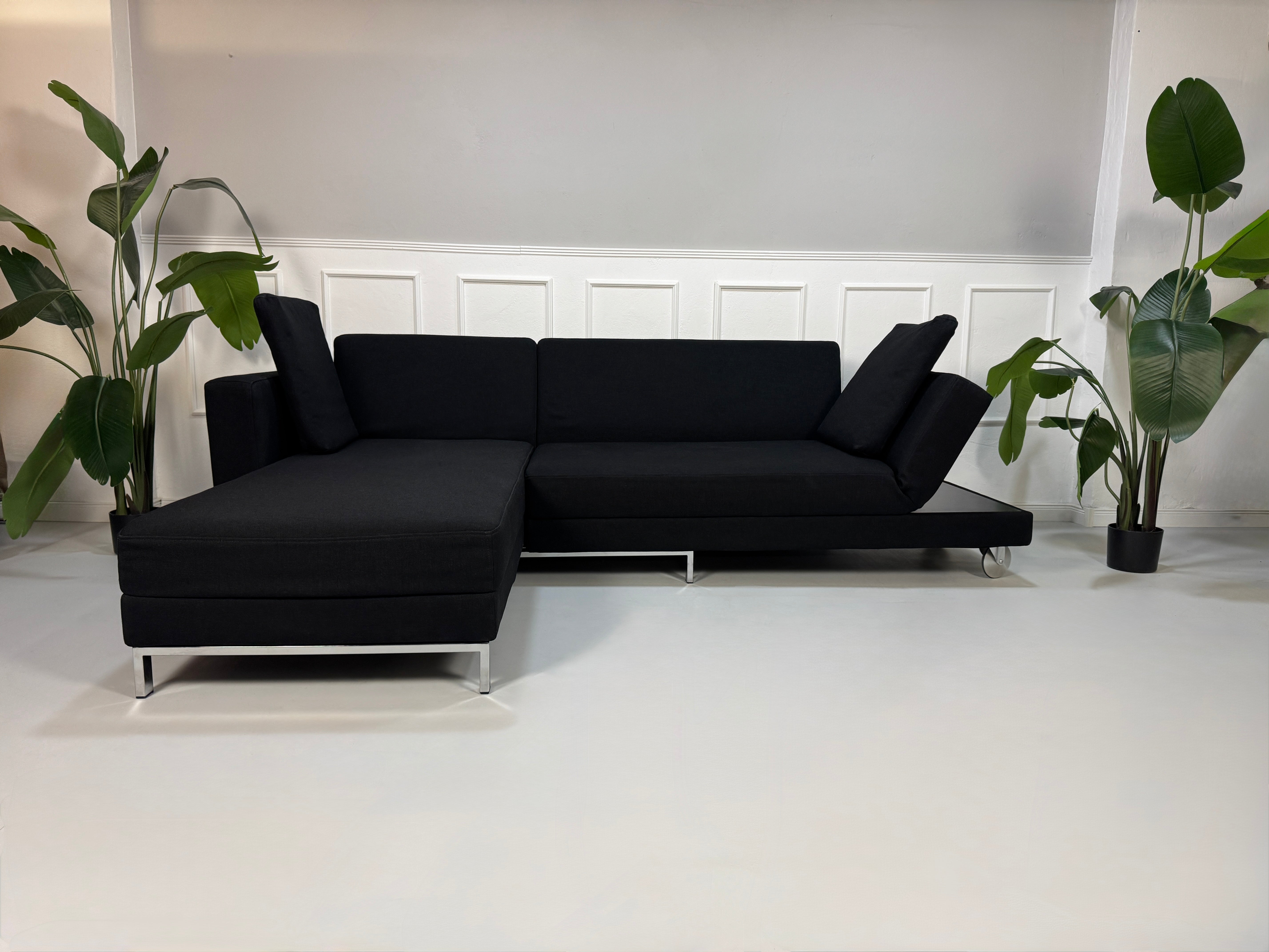Gebrauchtes Brühl Four Two Designer Stoff Sofa in der Farbe Schwarz vor einer Wand, stilvoll und modern eingerichtet.