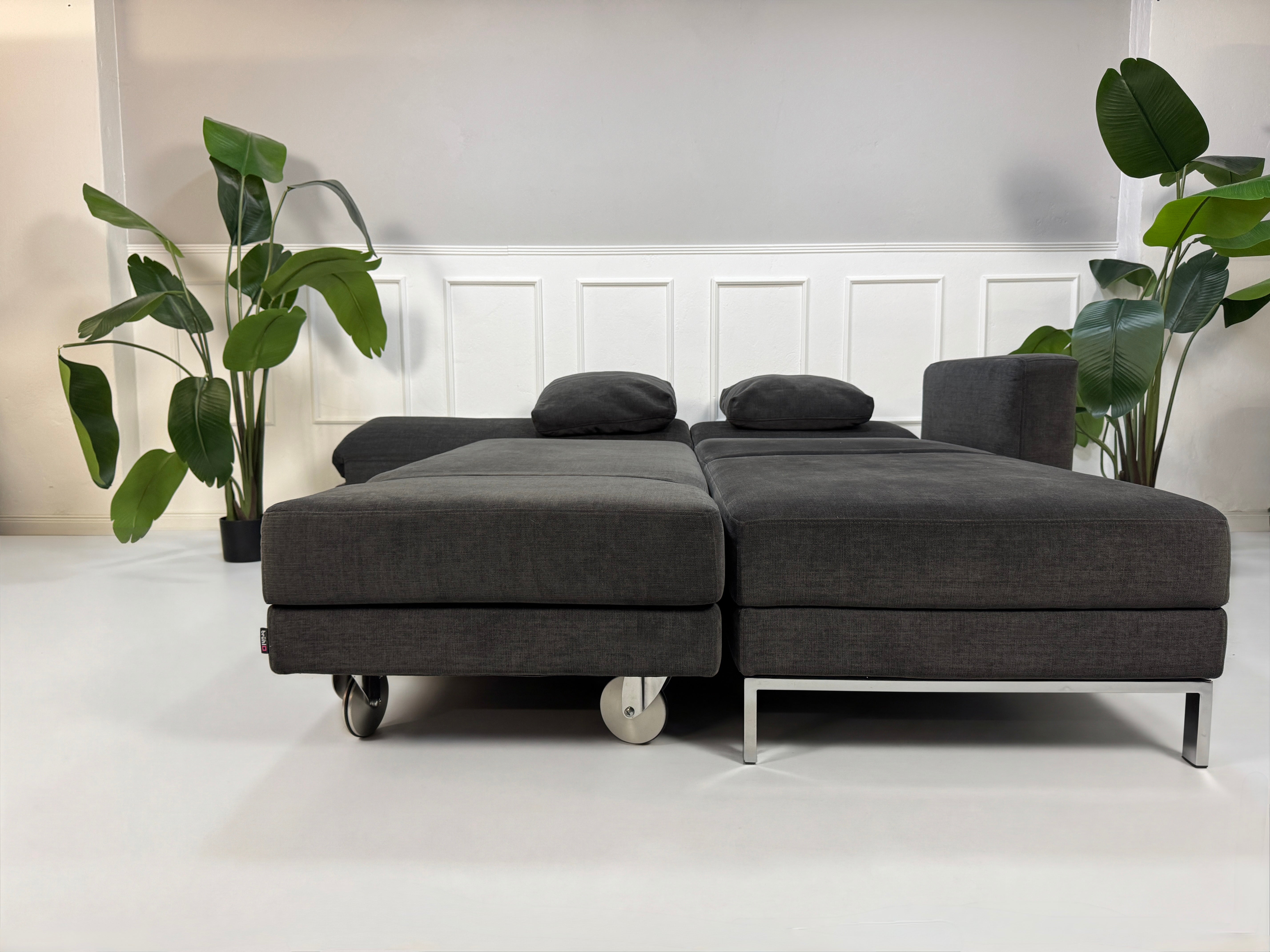 Gebrauchtes Brühl FourTwo Designer Stoff Sofa in der Farbe Grau vor einer Wand, stilvoll und modern eingerichtet.