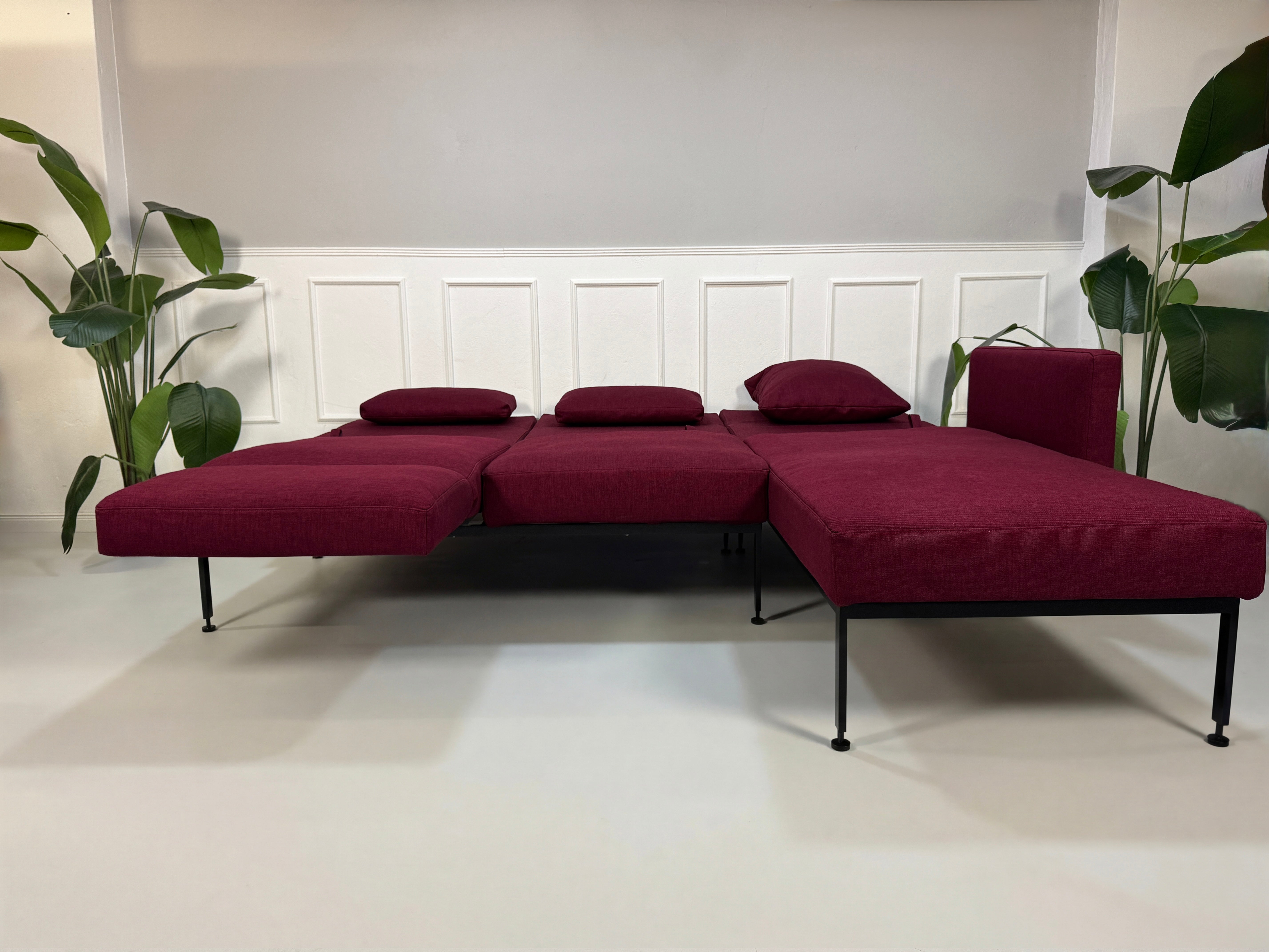 Gebrauchtes Brühl Roro Soft Designer Stoff Ecksofa in der Farbe Rot vor einer Wand, stilvoll und modern eingerichtet.