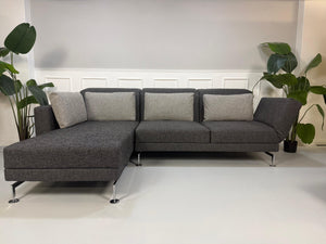 Gebrauchtes Brühl Moule Designer Stoff Sofa in der Farbe Grau vor einer Wand, stilvoll und modern eingerichtet.