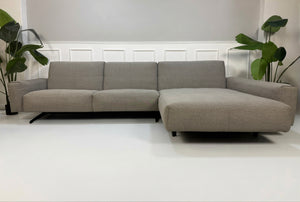 Gebrauchtes graues Rolf Benz 50 Designer Stoff Sofa vor einer Wand, stilvoll und modern eingerichtet.