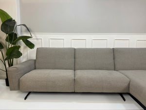 Gebrauchtes graues Rolf Benz 50 Designer Stoff Sofa vor einer Wand, stilvoll und modern eingerichtet.