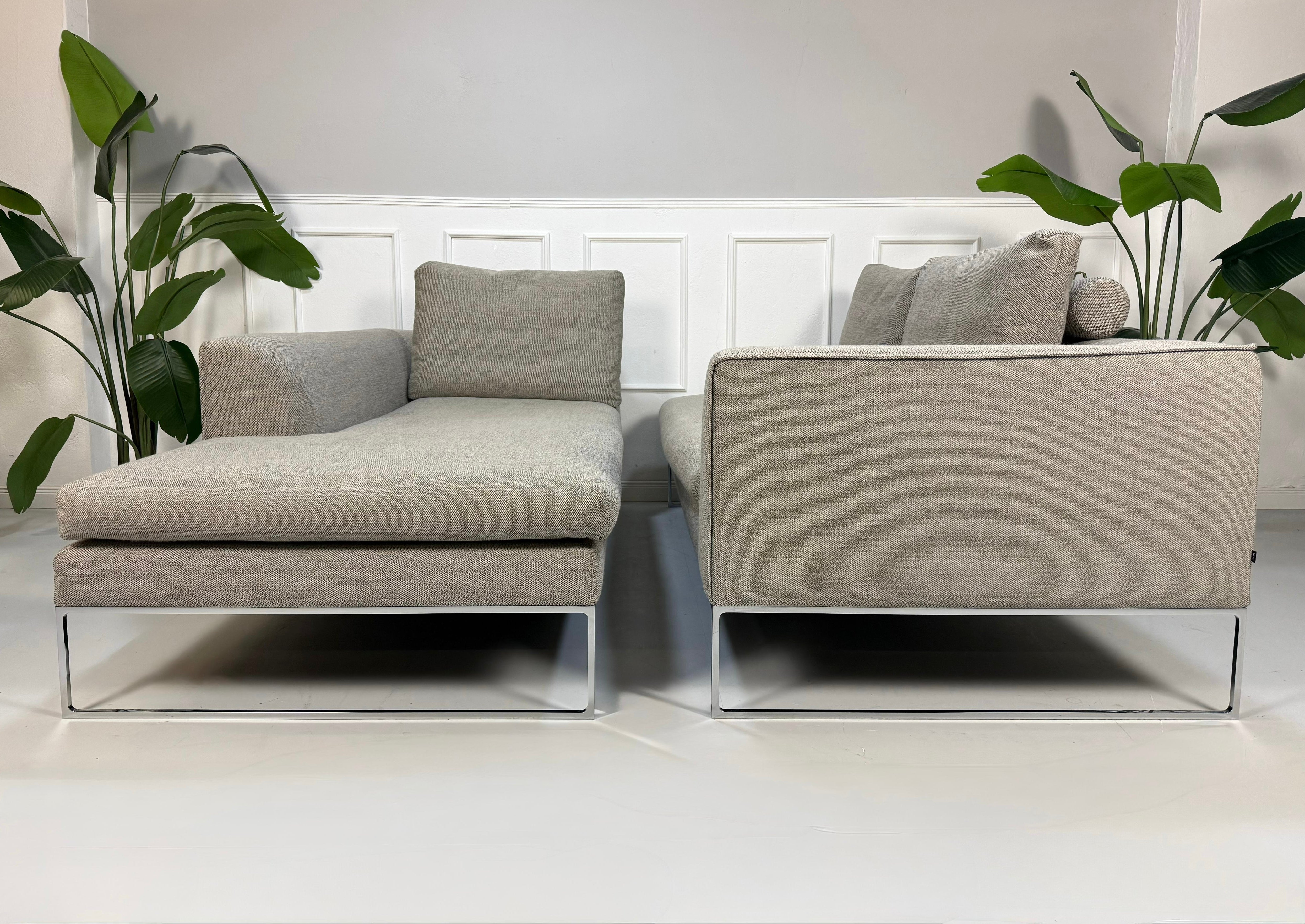 Gebrauchtes graues COR Mell Lounge Designer Stoff Sofa vor einer Wand, stilvoll und modern eingerichtet.