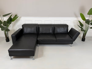 Refurbished Brühl Moule Designer Leder Sofa vor einer Wand, stilvoll und modern eingerichtet.
