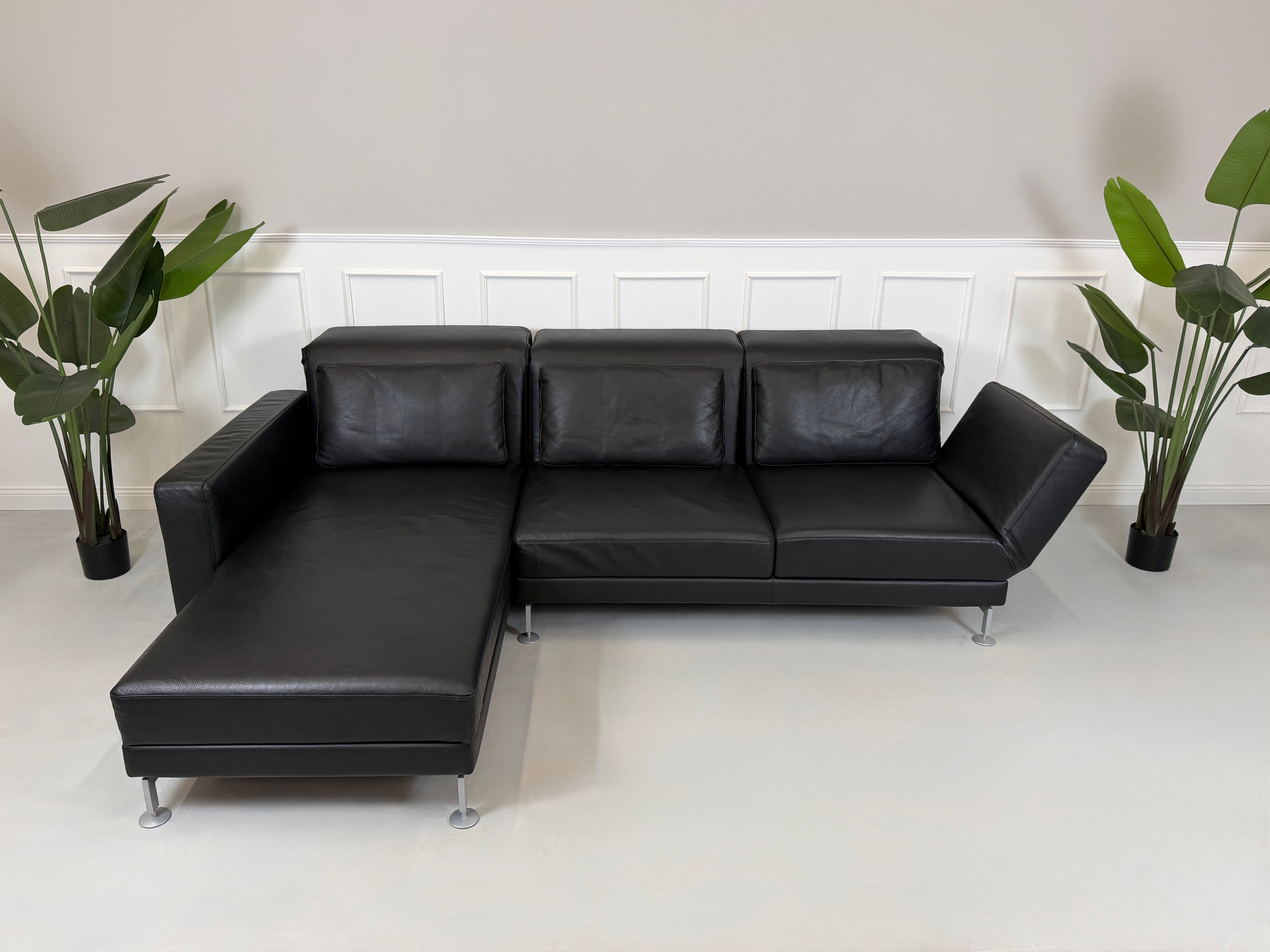 Refurbished Brühl Moule Designer Leder Sofa vor einer Wand, stilvoll und modern eingerichtet.
