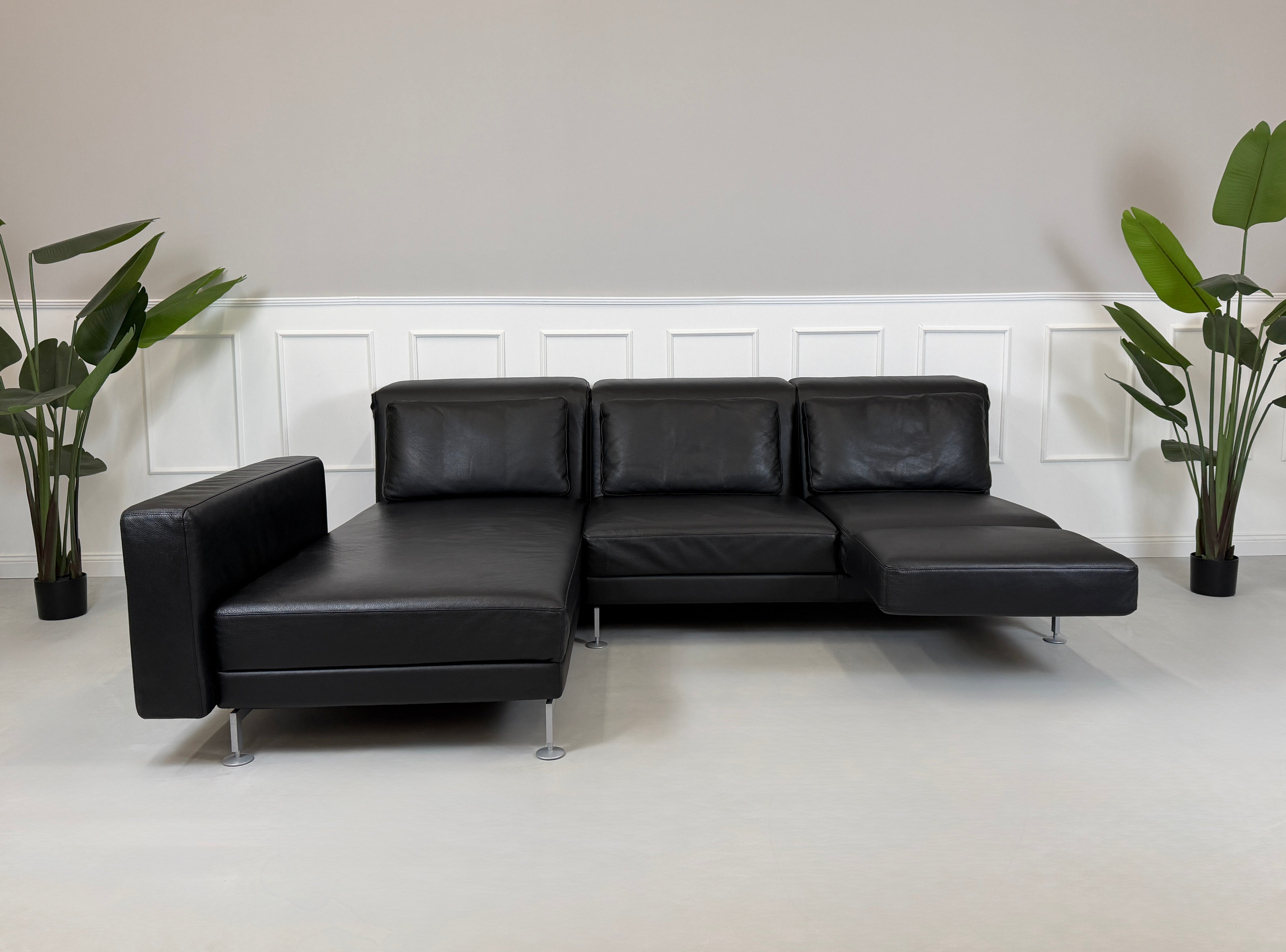 Refurbished Brühl Moule Designer Leder Sofa vor einer Wand, stilvoll und modern eingerichtet.