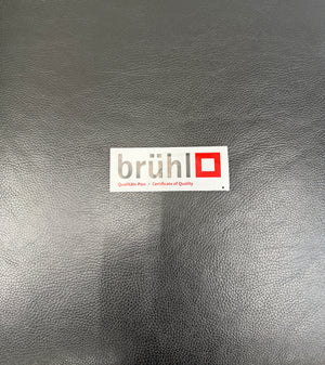 Refurbished Brühl Moule Designer Leder Sofa vor einer Wand, stilvoll und modern eingerichtet.