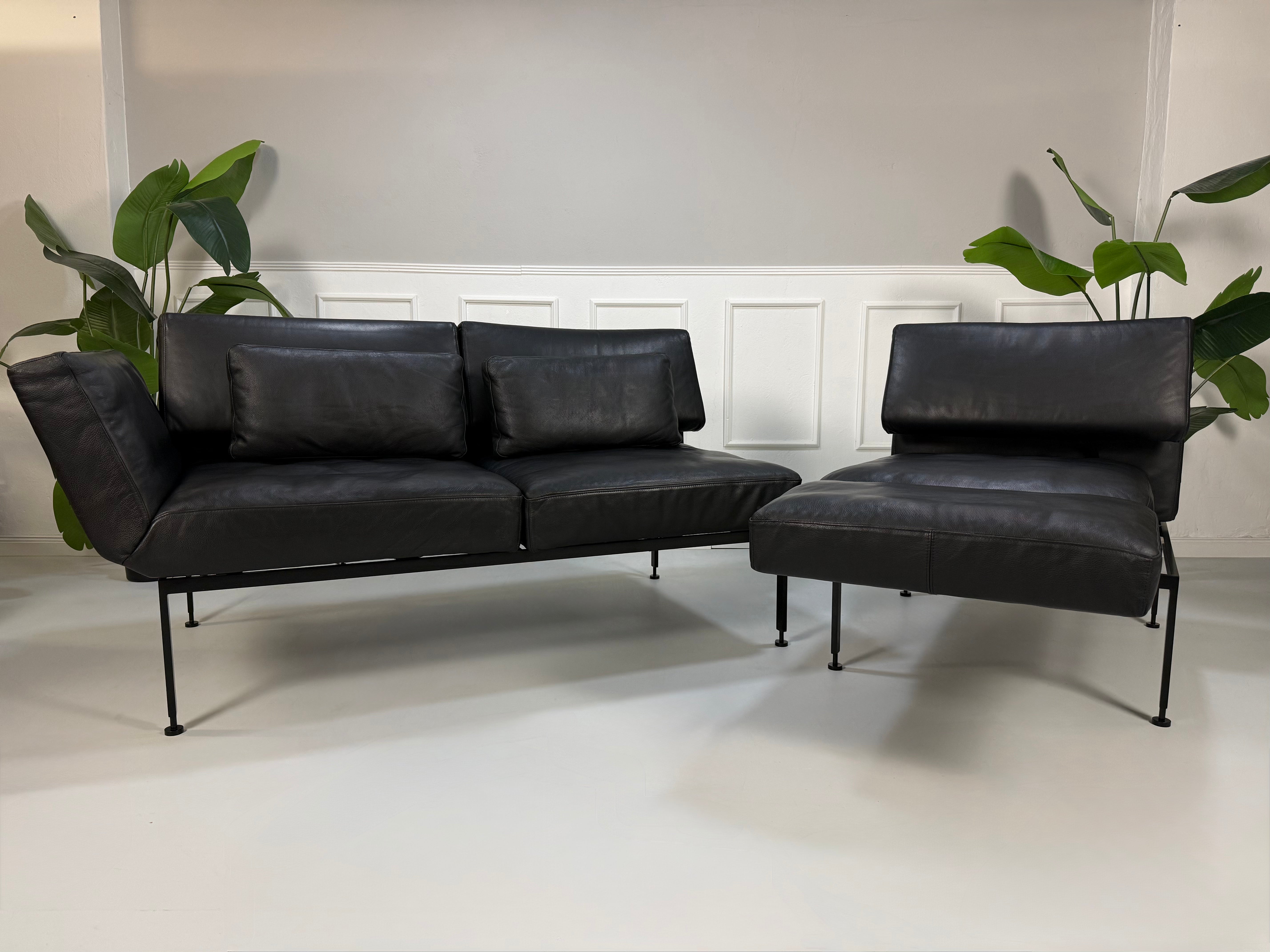 Gebrauchtes Brühl Roro Soft Designer Leder Sofa in der Farbe Schwarz vor einer Wand, stilvoll und modern eingerichtet.
