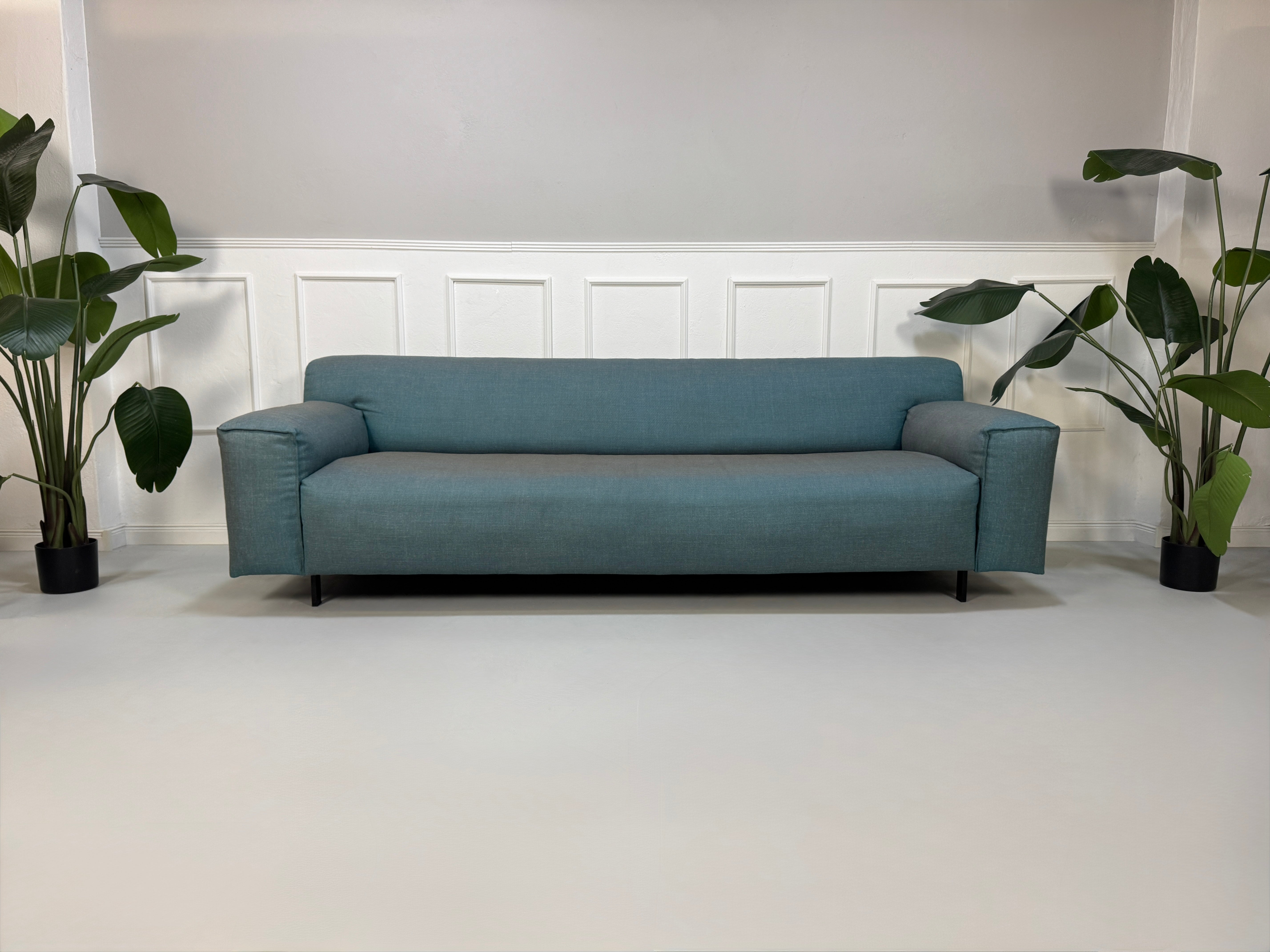 Gebrauchtes Rolf Benz Grata Designer Stoff Sofa in der Farbe Blau vor einer Wand, stilvoll und modern eingerichtet.