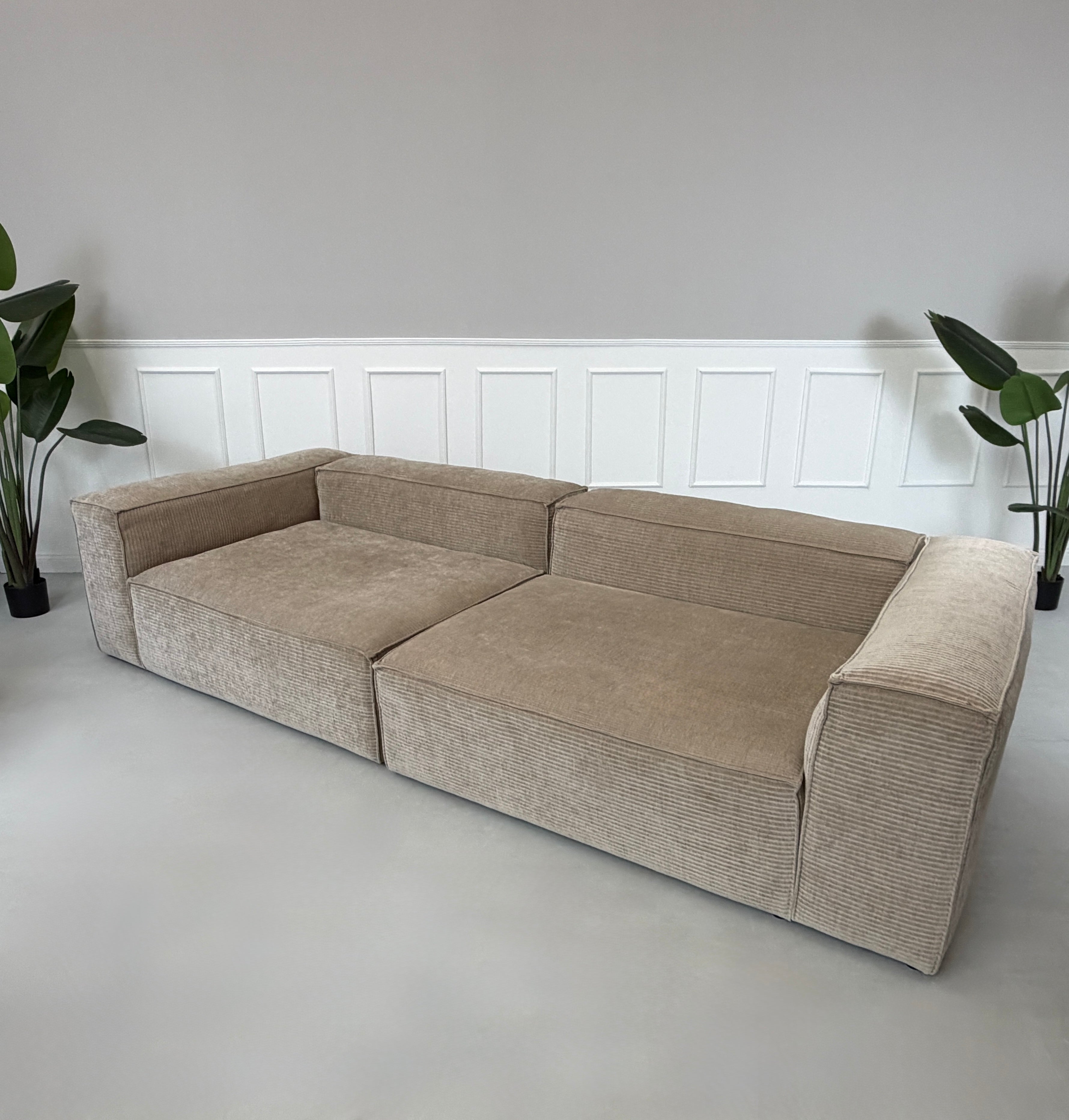 Erneuertes beiges Bolia Cosima Designer Cord Sofa vor einer Wand, stilvoll und modern eingerichtet.