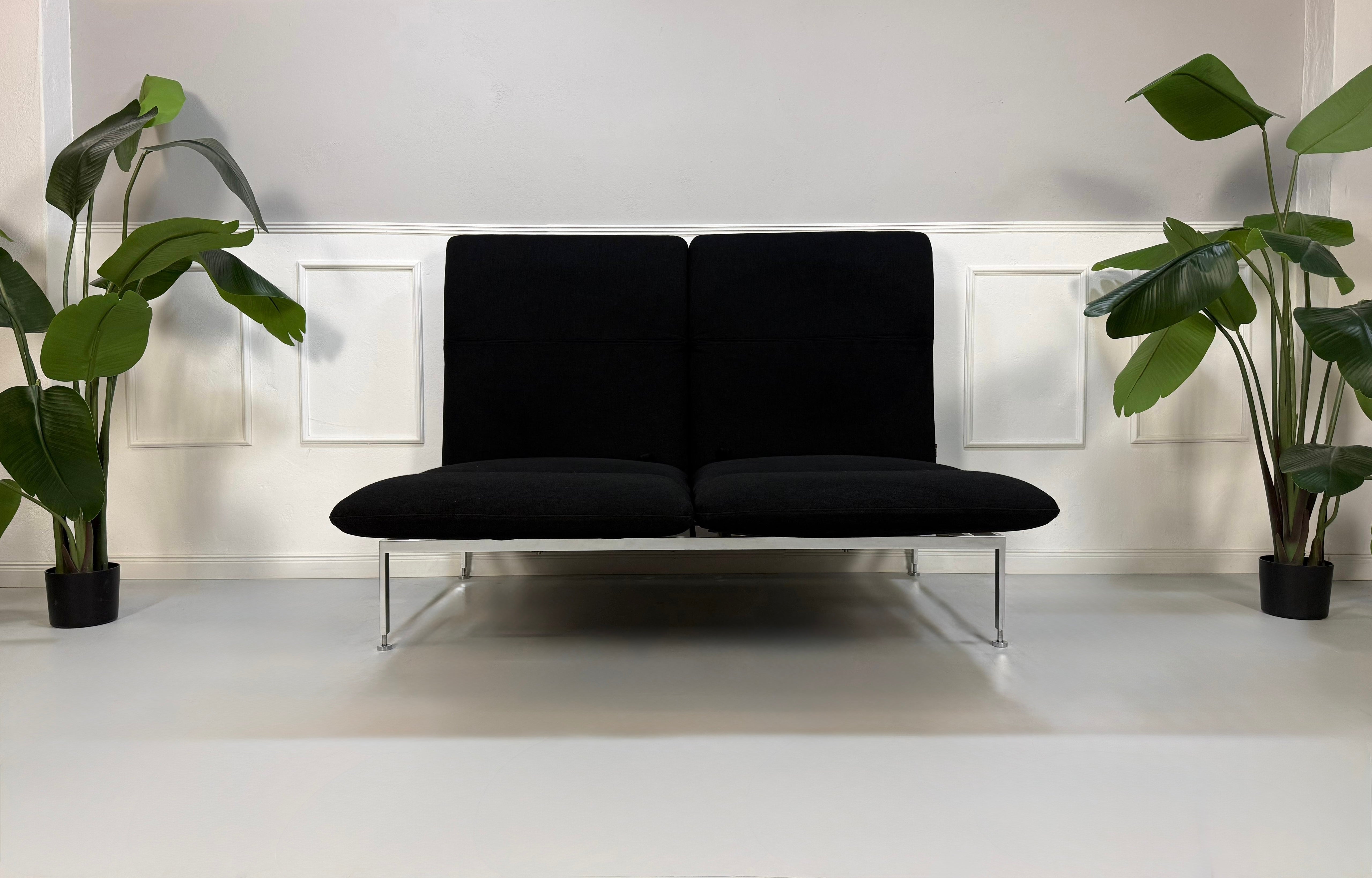 Gebrauchtes schwarzes Brühl Roro Designer Stoff Sofa vor einer Wand, stilvoll und modern eingerichtet.