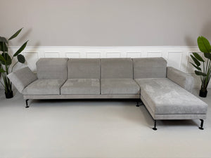 Graues Ausstellungsstück Brühl Moule Designer Stoff Sofa vor einer Wand, stilvoll und modern eingerichtet.