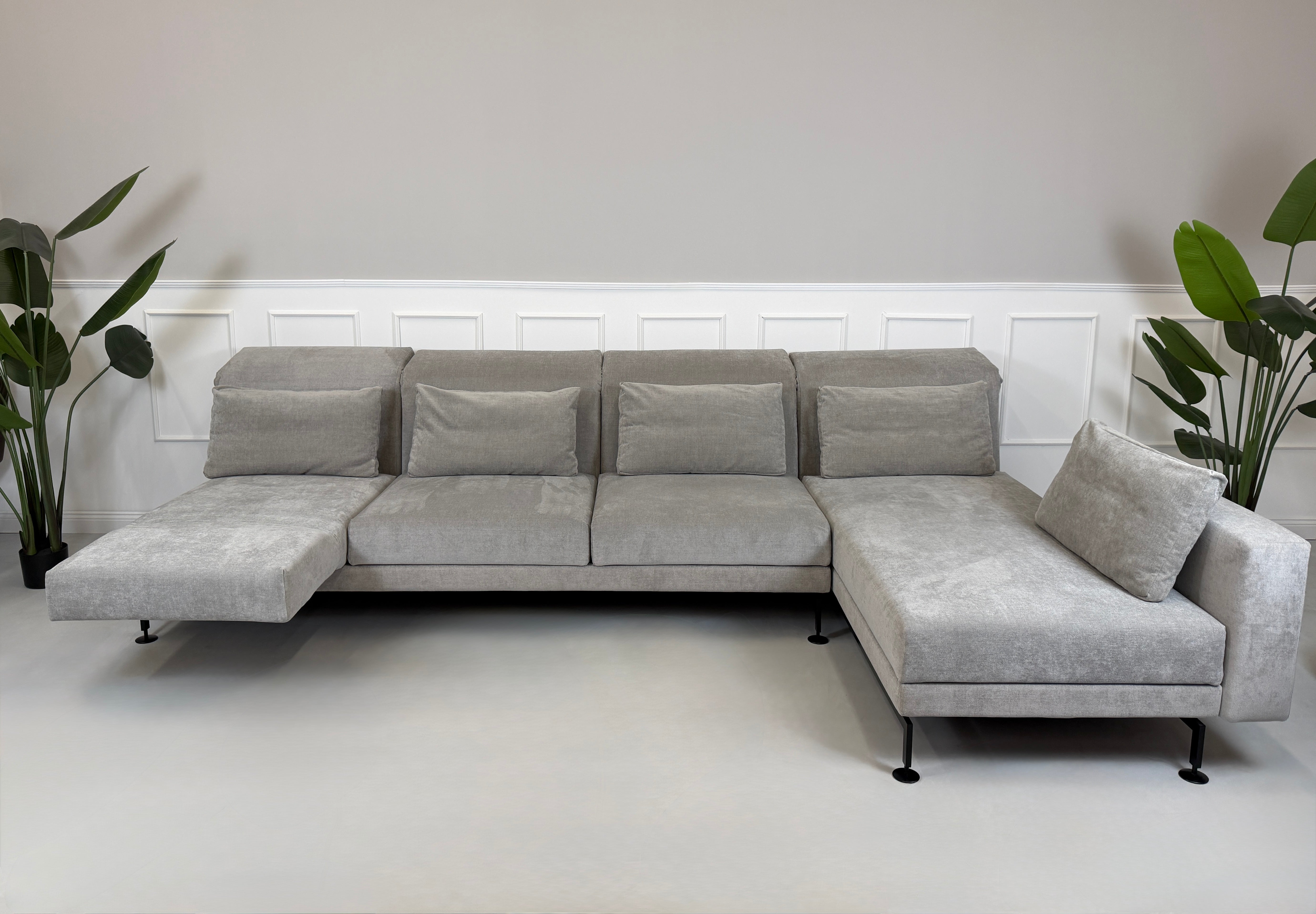 Graues Ausstellungsstück Brühl Moule Designer Stoff Sofa vor einer Wand, stilvoll und modern eingerichtet.