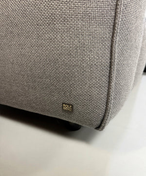 Erneuertes graues Rolf Benz Mio Designer Stoff Sofa vor einer Wand, stilvoll und modern eingerichtet.