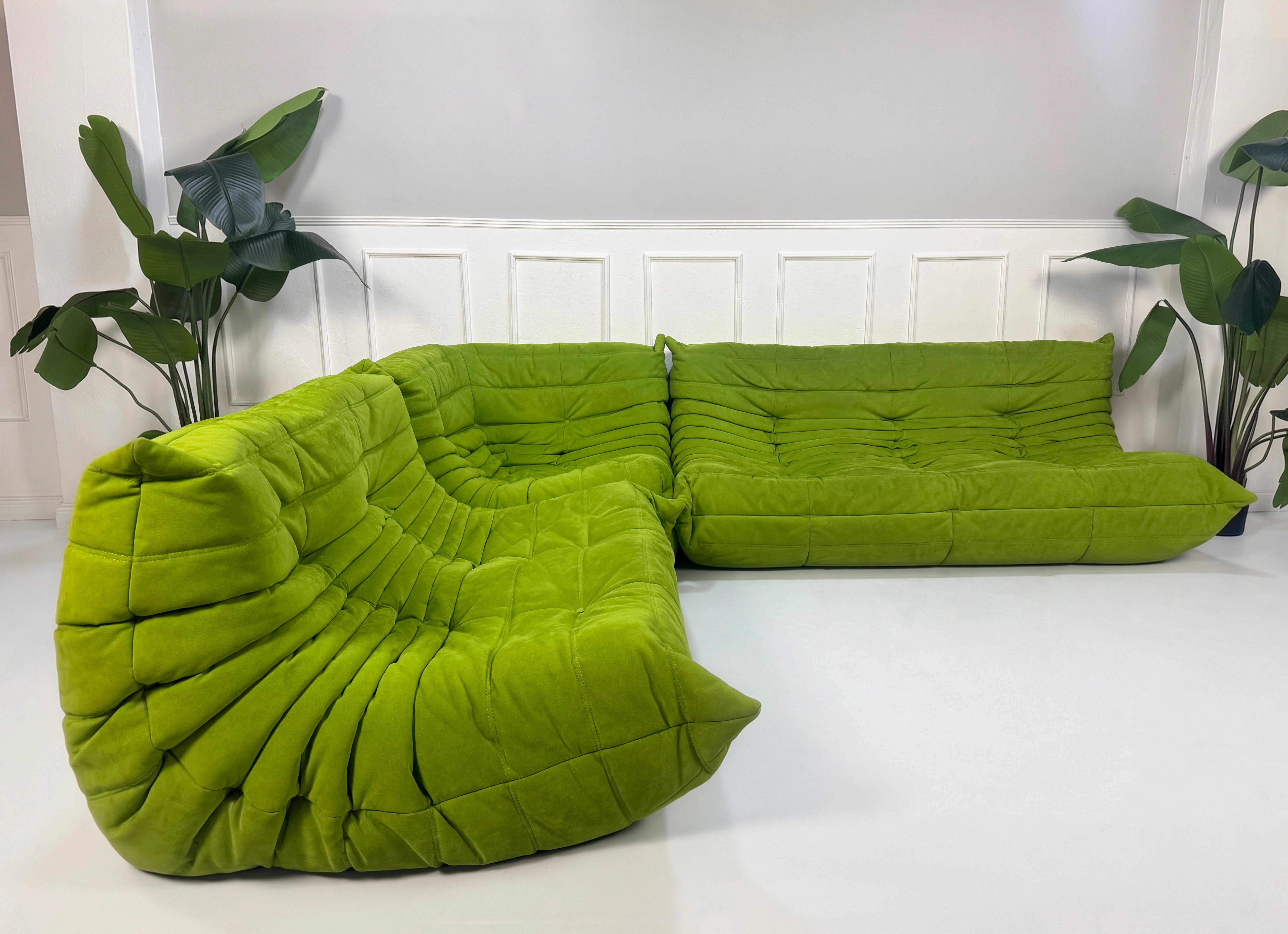Gebrauchtes Refurbished grünes Ligne Roset Togo Designer Stoff Sofa vor einer Wand, stilvoll und modern eingerichtet.