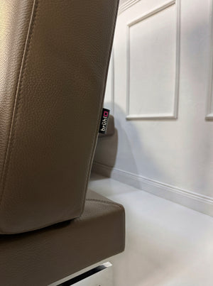 Gebrauchtes braunes Brühl Moule Designer Leder Sofa vor einer Wand, stilvoll und modern eingerichtet.