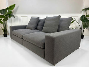 Refurbished graues Flexform Groundpiece Designer Stoff Sofa vor einer Wand, stilvoll und modern eingerichtet.
