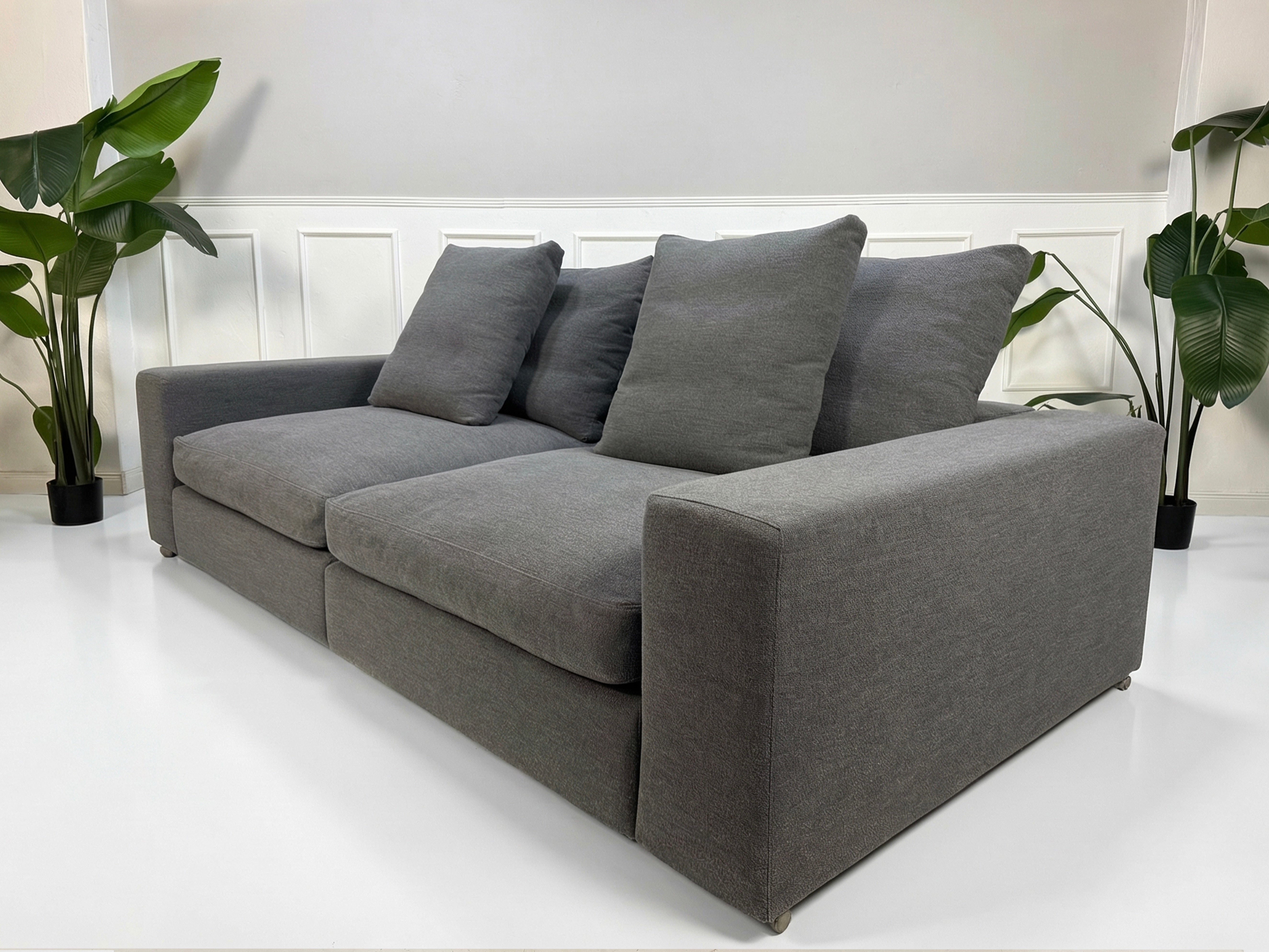 Refurbished graues Flexform Groundpiece Designer Stoff Sofa vor einer Wand, stilvoll und modern eingerichtet.