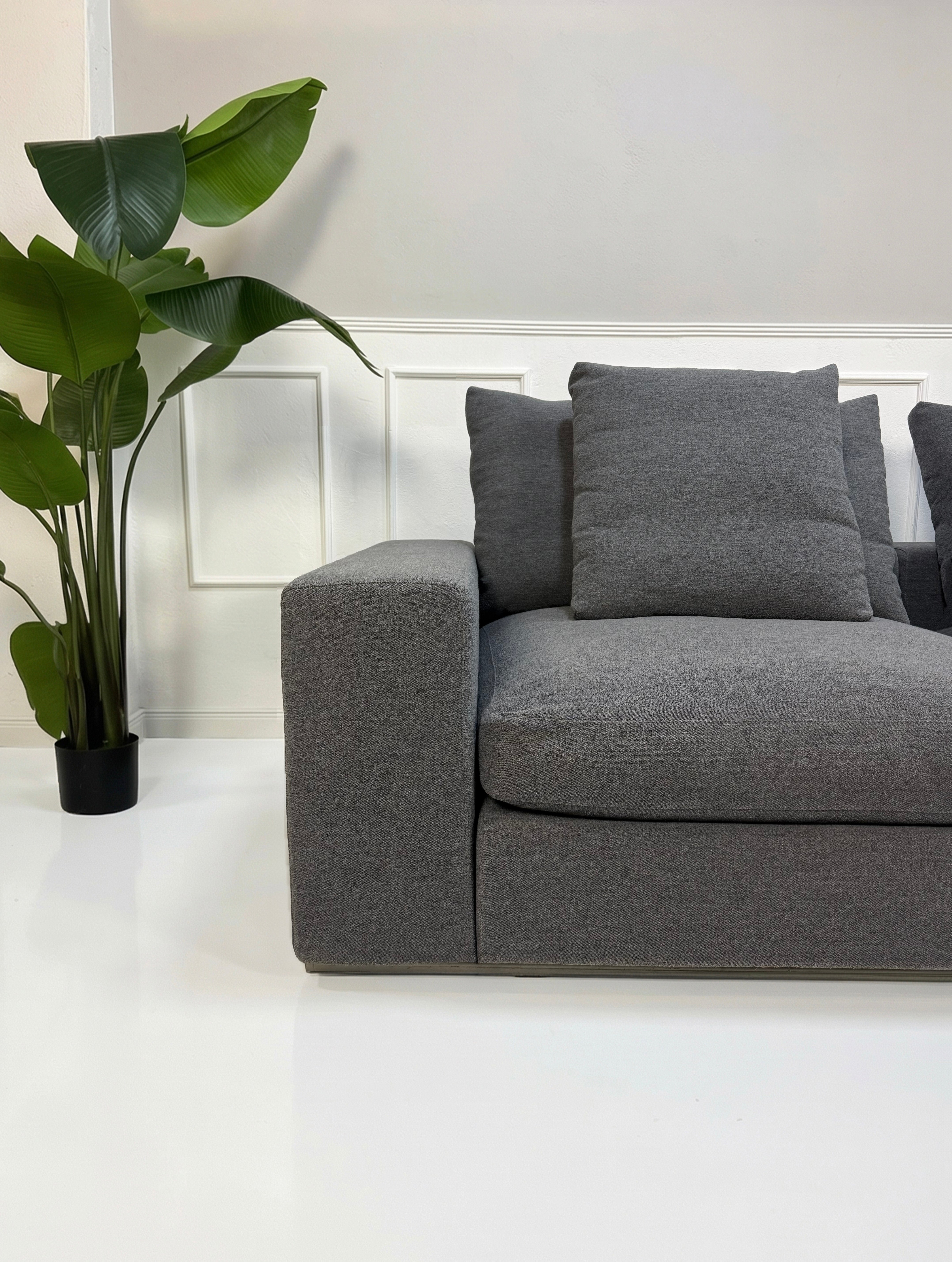 Refurbished graues Flexform Groundpiece Designer Stoff Sofa vor einer Wand, stilvoll und modern eingerichtet.