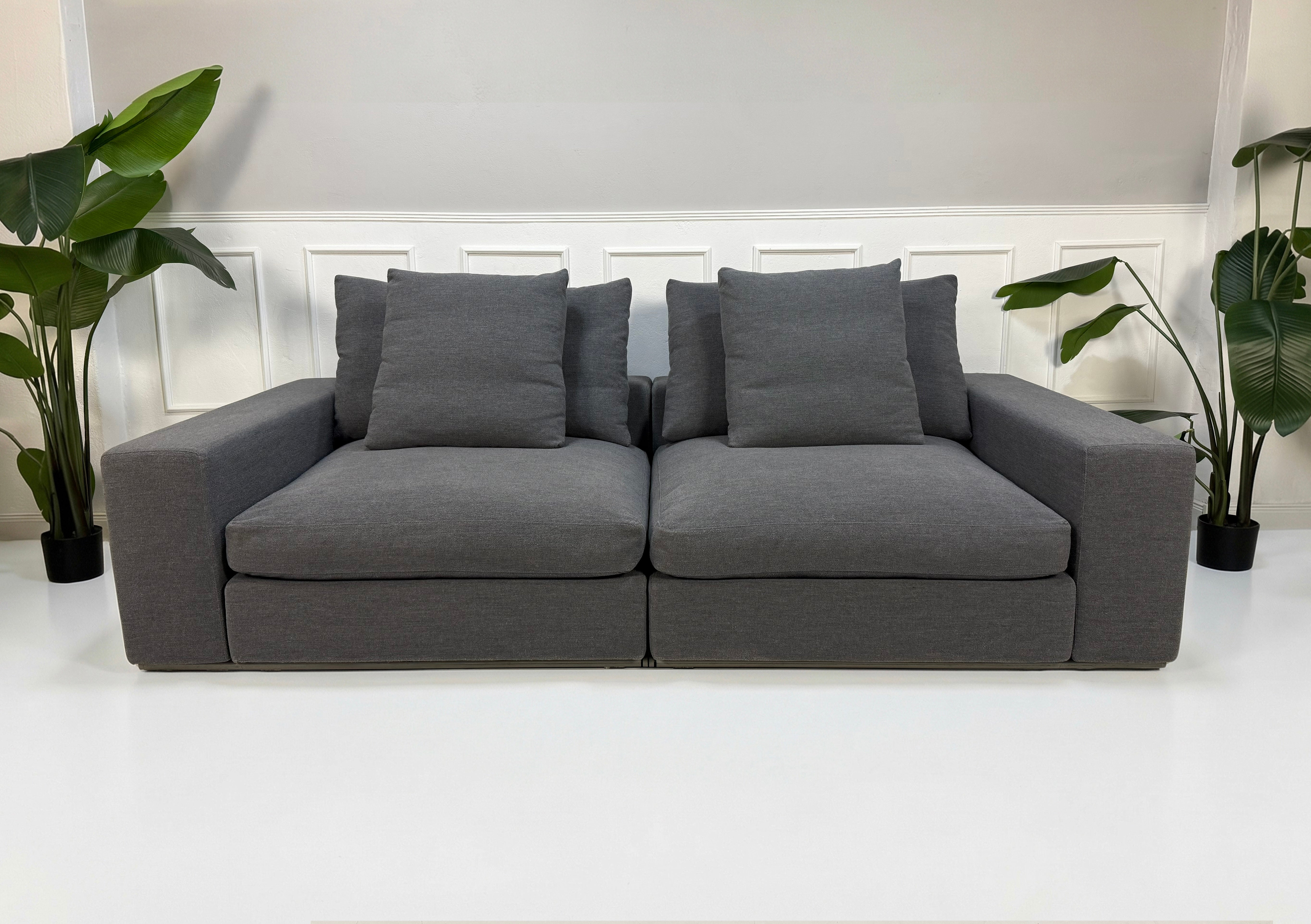 Refurbished graues Flexform Groundpiece Designer Stoff Sofa vor einer Wand, stilvoll und modern eingerichtet.
