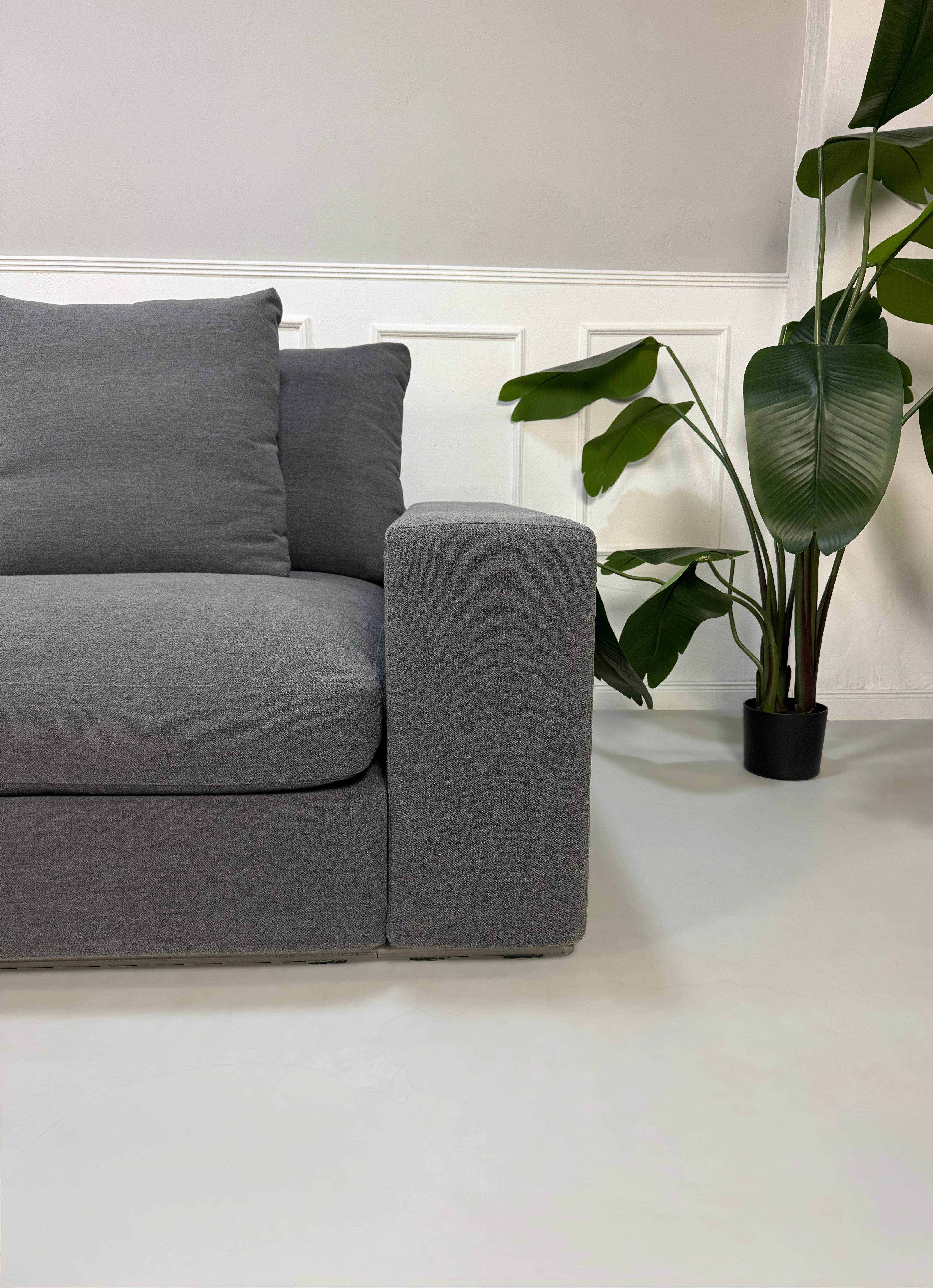 Refurbished graues Flexform Groundpiece Designer Stoff Sofa vor einer Wand, stilvoll und modern eingerichtet.