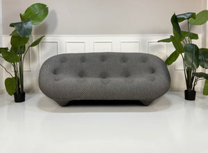 Refurbished graues Ligne Roset Ploum Designer Stoff Sofa vor einer Wand, stilvoll und modern eingerichtet.