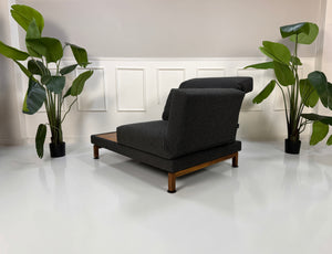 Gebrauchter Brühl Moule Designer Stoff Sessel vor einer Wand, stilvoll und modern eingerichtet.