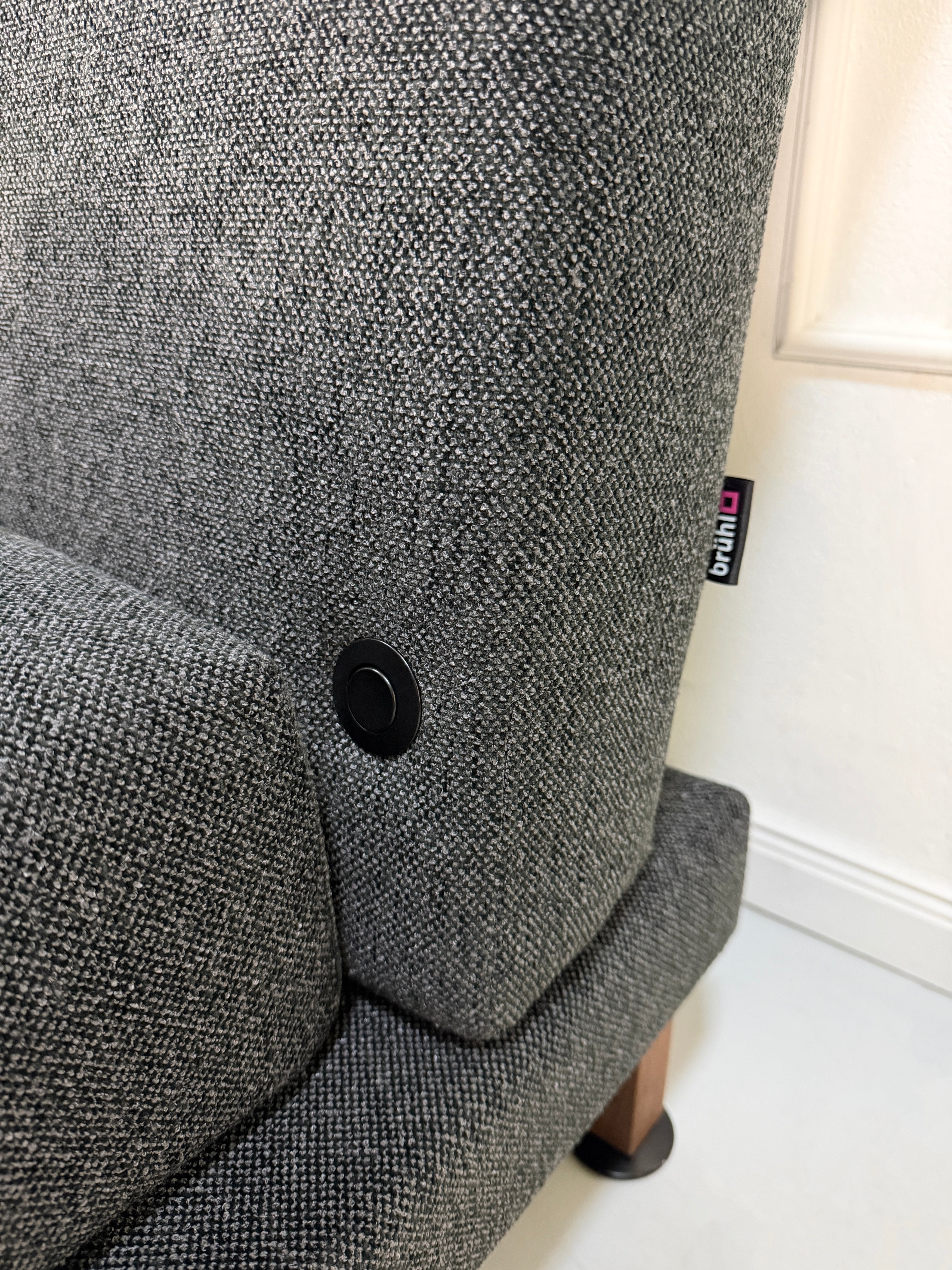 Gebrauchter Brühl Moule Designer Stoff Sessel vor einer Wand, stilvoll und modern eingerichtet.