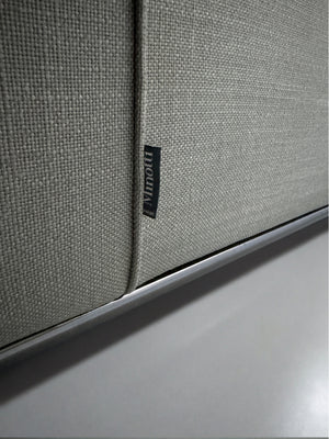 Gebrauchtes graues Minotti Hamilton Designer Stoff Sofa vor einer Wand, stilvoll und modern eingerichtet.